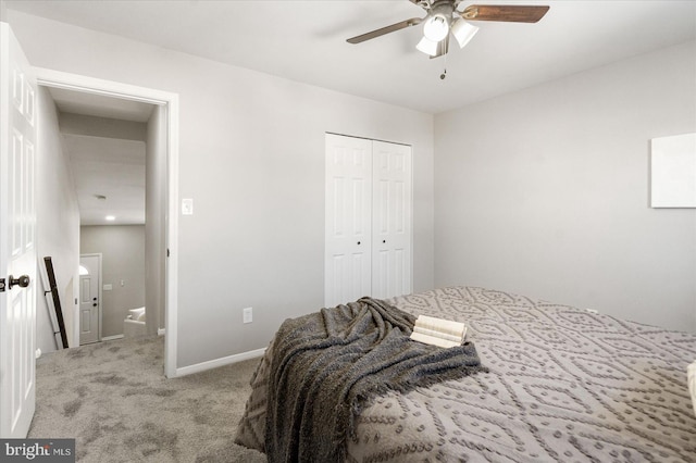 bedroom featuring ceiling fan, light colored carpet, and a closet