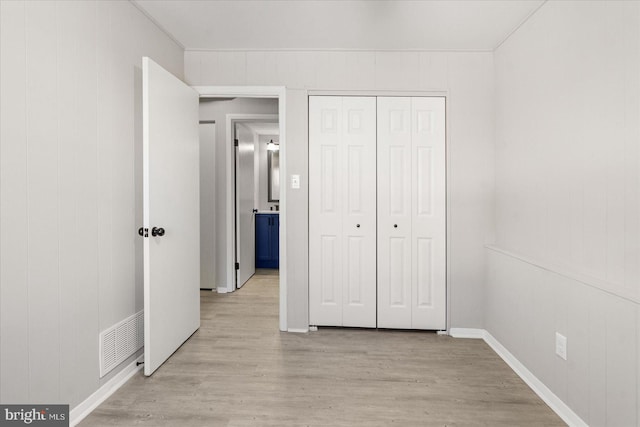 unfurnished bedroom with a closet and light wood-type flooring