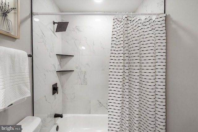 bathroom featuring tiled shower / bath and toilet