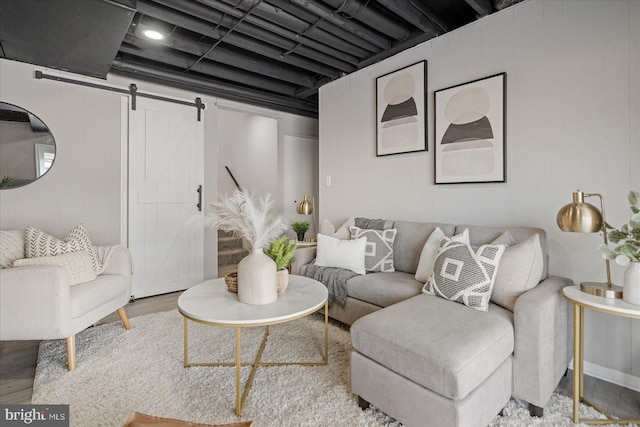 living room featuring a barn door and light hardwood / wood-style flooring