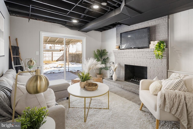 living room featuring a brick fireplace and hardwood / wood-style flooring