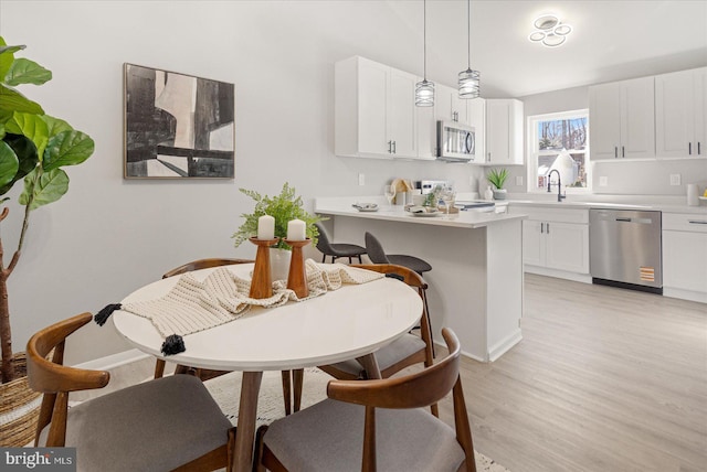 dining room with sink and light hardwood / wood-style flooring