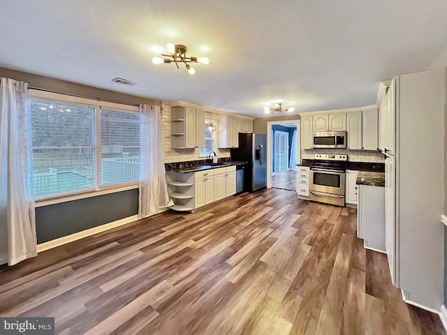 kitchen featuring a notable chandelier, visible vents, appliances with stainless steel finishes, open shelves, and dark countertops