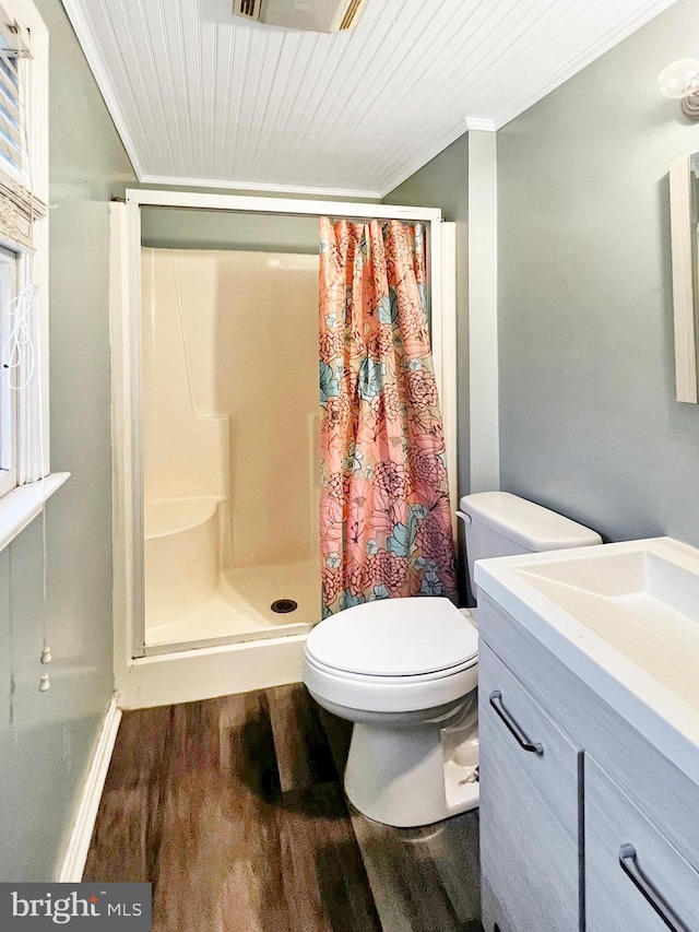 full bath featuring crown molding, toilet, a stall shower, vanity, and wood finished floors