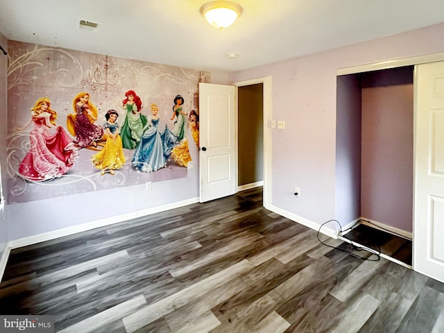 interior space featuring dark wood-style flooring, visible vents, and baseboards