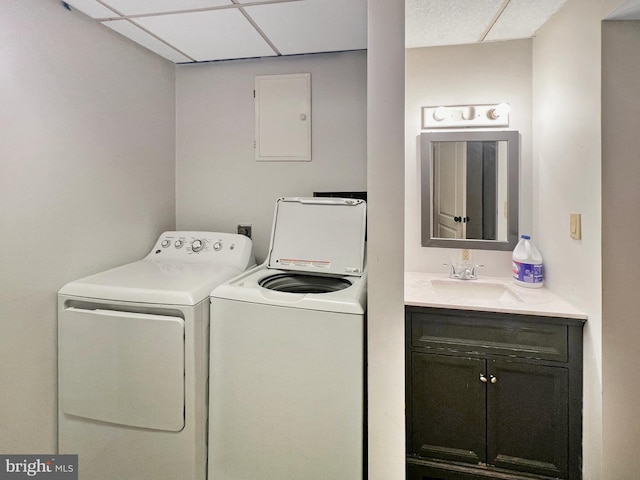 laundry room featuring laundry area, washing machine and dryer, electric panel, and a sink