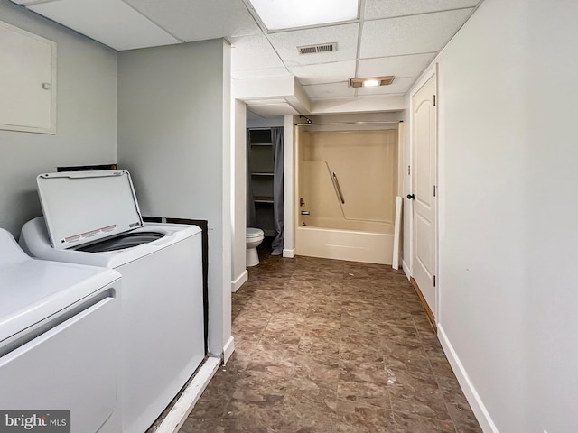 laundry area with baseboards, visible vents, washing machine and clothes dryer, and laundry area