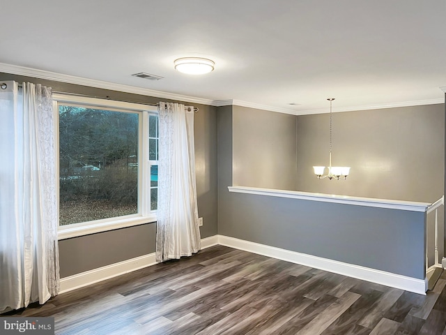 spare room with dark wood finished floors, crown molding, visible vents, a chandelier, and baseboards