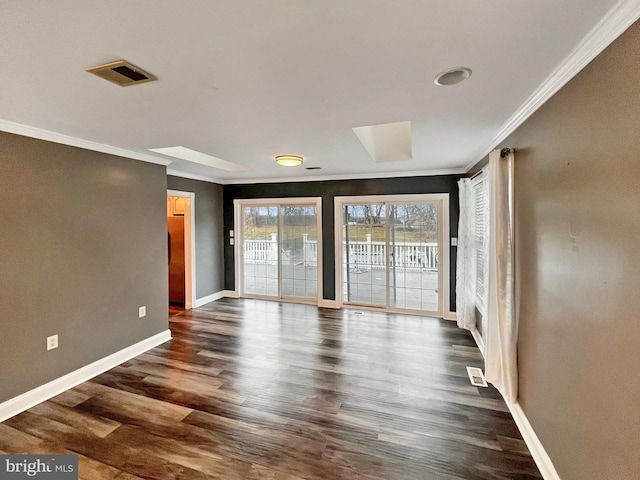 spare room with baseboards, dark wood-type flooring, visible vents, and crown molding