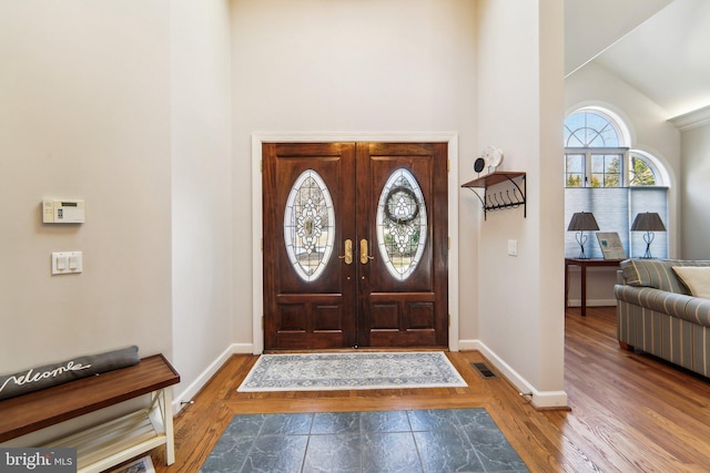 foyer entrance featuring hardwood / wood-style flooring and high vaulted ceiling