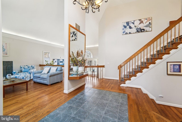 entrance foyer featuring hardwood / wood-style flooring, a chandelier, and a towering ceiling