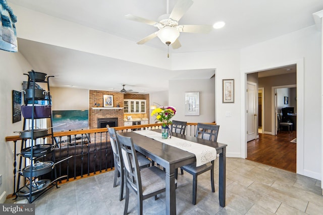 dining room featuring a fireplace and ceiling fan