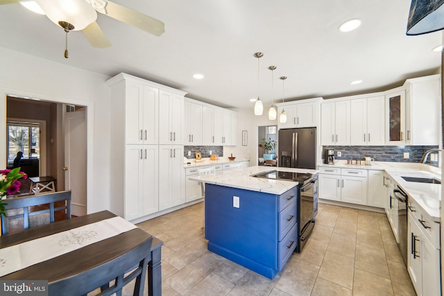 kitchen with a kitchen island, decorative light fixtures, sink, light stone counters, and black appliances