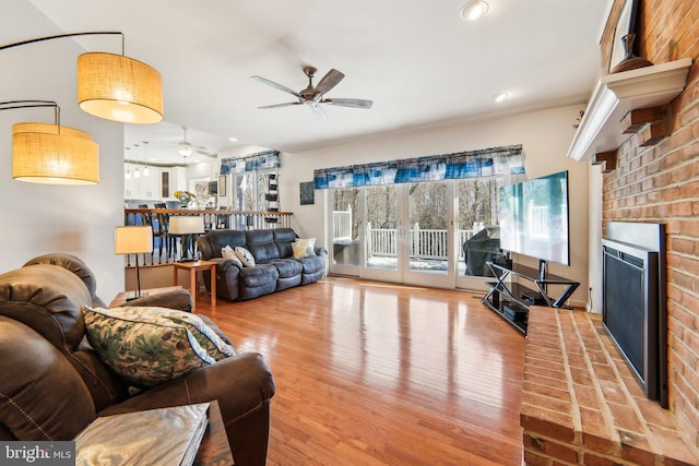 living room with hardwood / wood-style floors, a fireplace, and ceiling fan