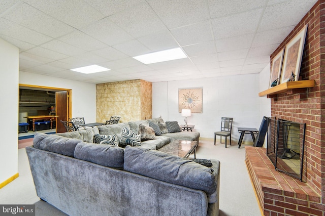 carpeted living room with a brick fireplace and a paneled ceiling