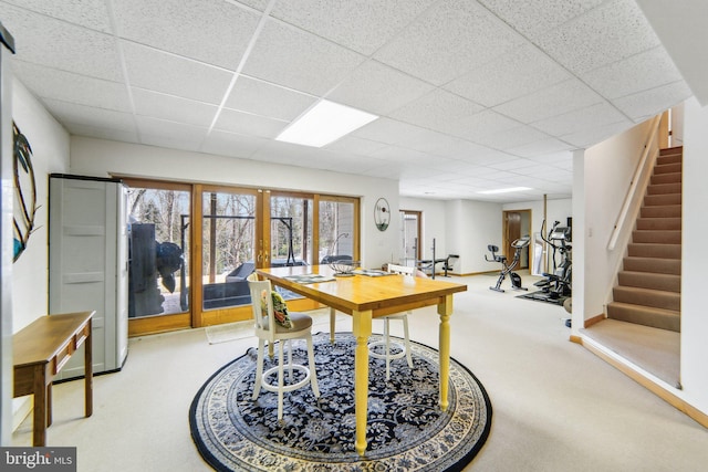 carpeted office featuring french doors and a drop ceiling