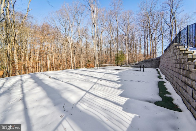 snowy yard featuring tennis court