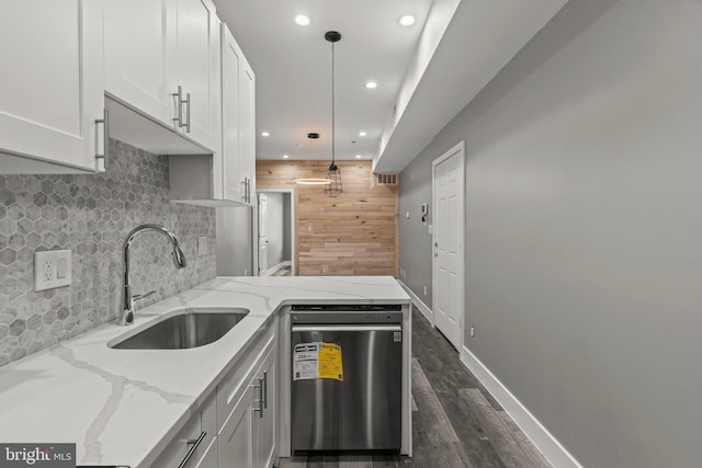 kitchen featuring light stone countertops, dishwashing machine, white cabinets, sink, and hanging light fixtures