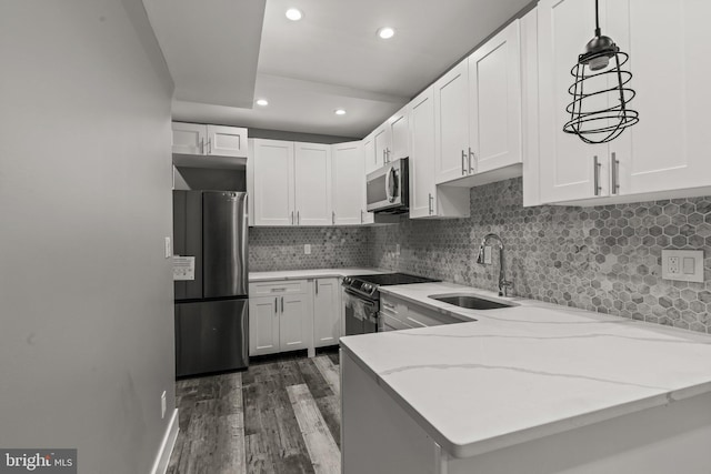 kitchen with white cabinets, kitchen peninsula, and appliances with stainless steel finishes