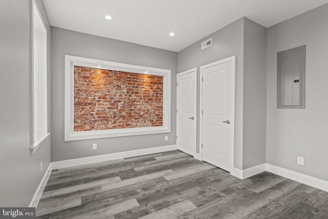 unfurnished bedroom featuring hardwood / wood-style floors and electric panel