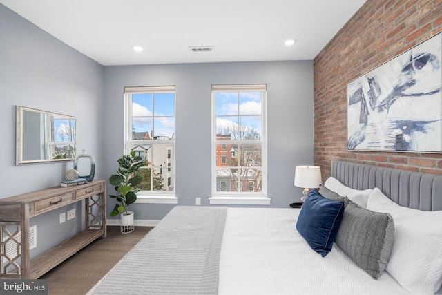 bedroom featuring multiple windows, radiator, and hardwood / wood-style floors