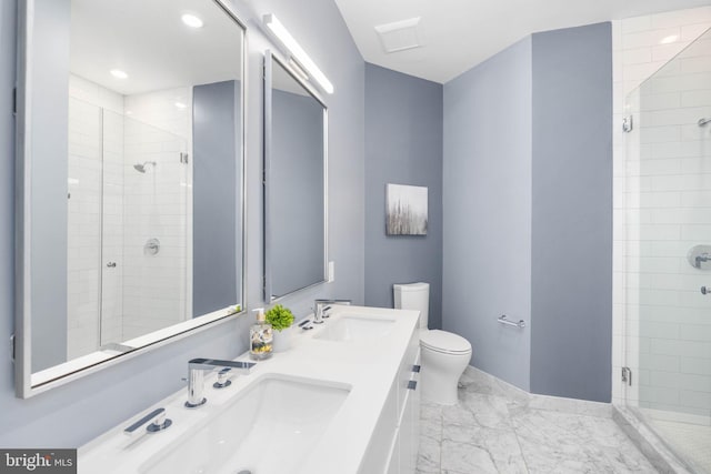 bathroom featuring vanity, a shower with door, and toilet