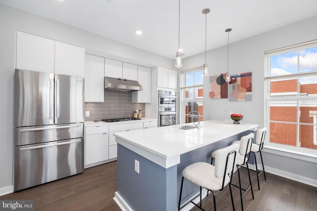 kitchen featuring white cabinetry, appliances with stainless steel finishes, sink, and pendant lighting