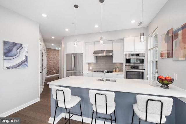 kitchen featuring decorative backsplash, appliances with stainless steel finishes, white cabinets, and decorative light fixtures