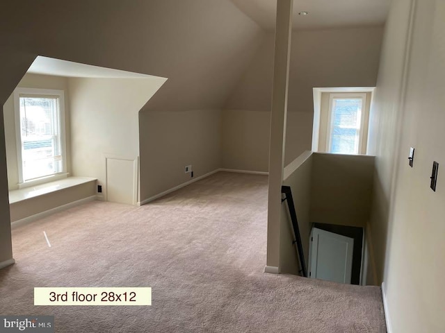 bonus room featuring lofted ceiling, a healthy amount of sunlight, and light colored carpet