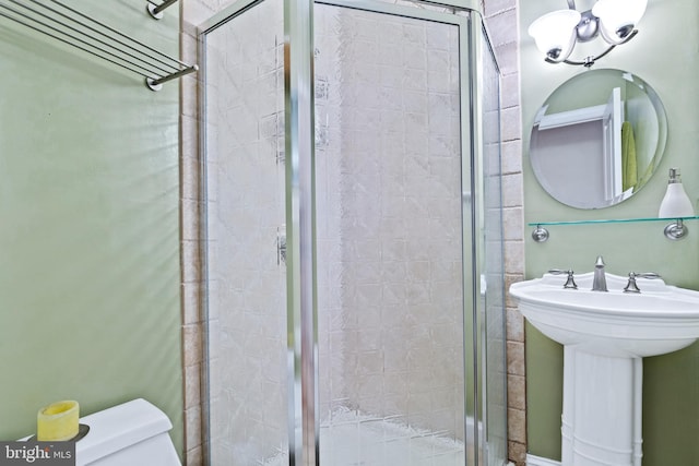 bathroom featuring sink, toilet, and an enclosed shower