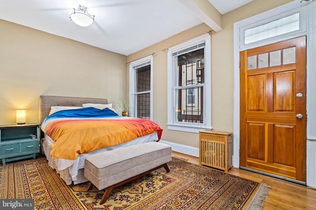 bedroom featuring beam ceiling and hardwood / wood-style floors