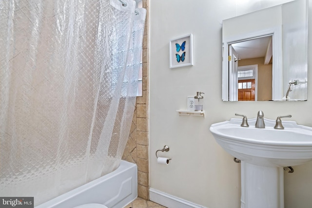 bathroom featuring sink and shower / bath combination with curtain