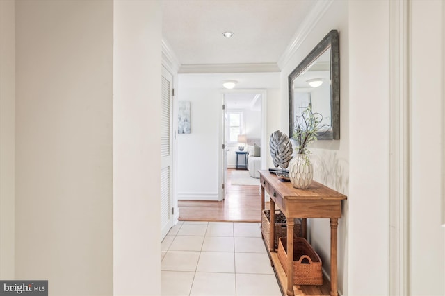 corridor with light tile patterned flooring and ornamental molding