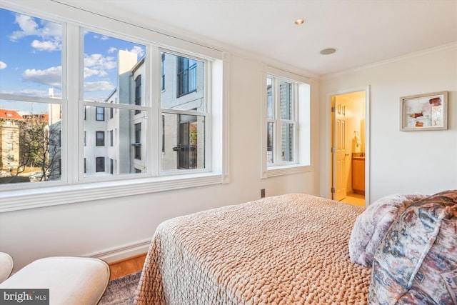 bedroom featuring crown molding and ensuite bath