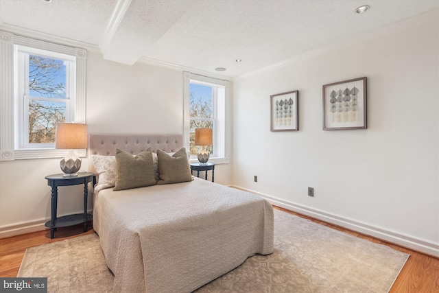 bedroom with hardwood / wood-style flooring, multiple windows, and a textured ceiling