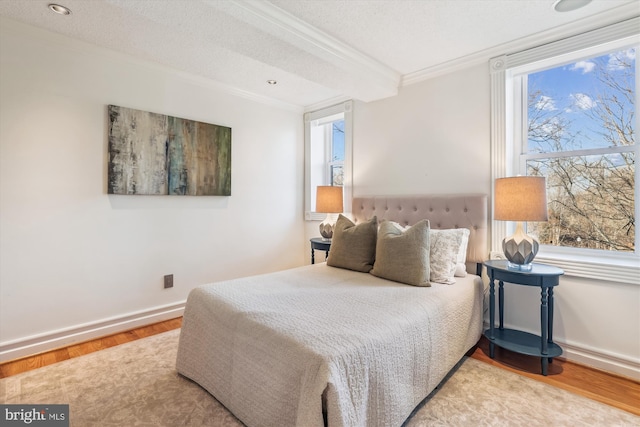 bedroom with multiple windows, ornamental molding, hardwood / wood-style floors, and a textured ceiling