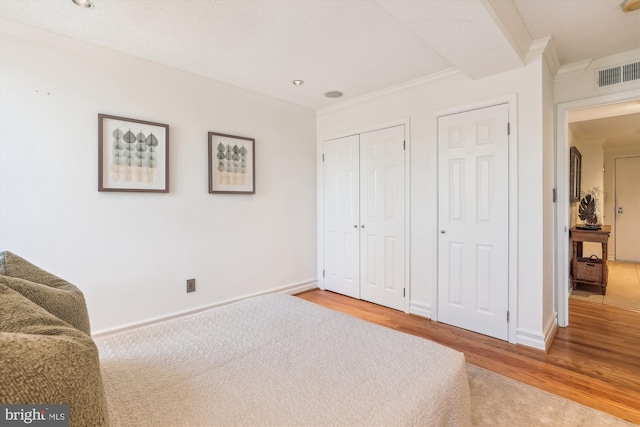 bedroom featuring ornamental molding and wood-type flooring