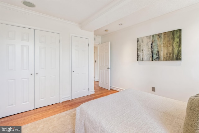 bedroom featuring ornamental molding, wood-type flooring, and a closet