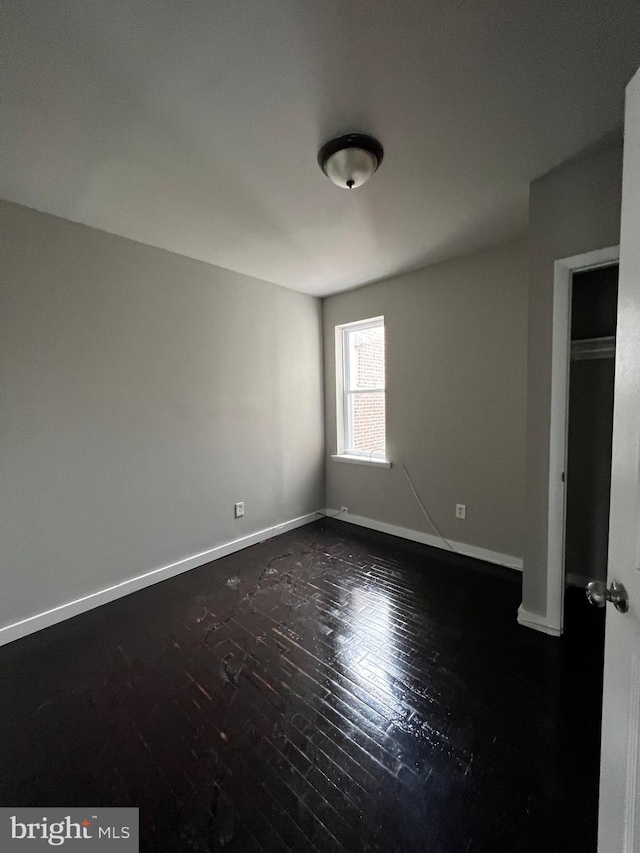 empty room with dark wood-type flooring