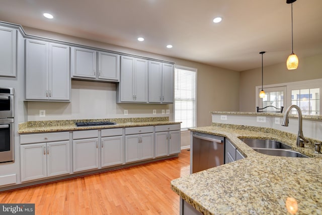 kitchen with sink, gray cabinetry, light hardwood / wood-style flooring, dishwasher, and black gas stovetop