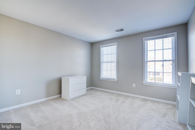 carpeted empty room featuring a wealth of natural light