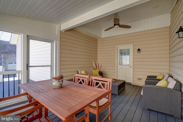 sunroom / solarium featuring beamed ceiling and ceiling fan