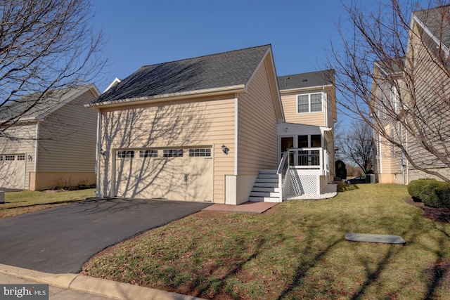 view of side of home featuring a garage, a lawn, and a sunroom