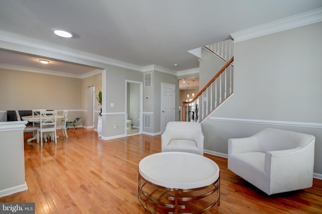 living area with crown molding and hardwood / wood-style flooring