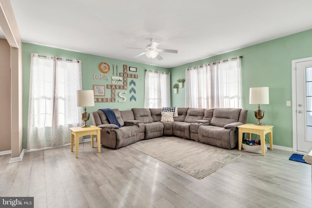 living room featuring light hardwood / wood-style floors and ceiling fan