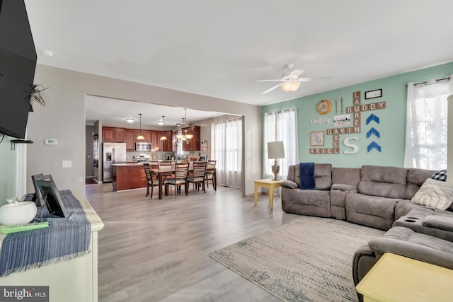 living room featuring light hardwood / wood-style floors and ceiling fan