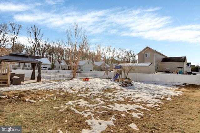 snowy yard with a gazebo and a playground