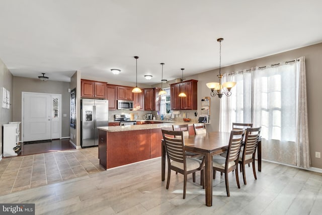 dining room with light hardwood / wood-style floors and a chandelier