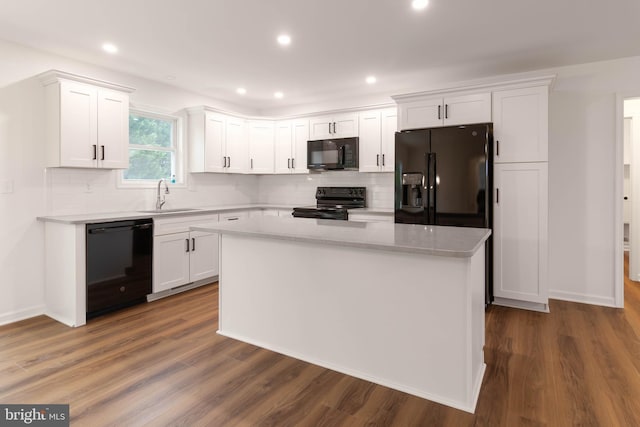 kitchen with a kitchen island, black appliances, white cabinets, and dark hardwood / wood-style flooring