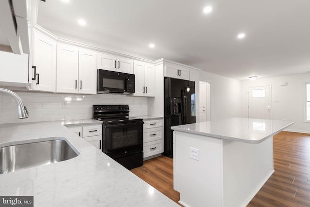 kitchen with sink, black appliances, white cabinetry, and dark wood-type flooring